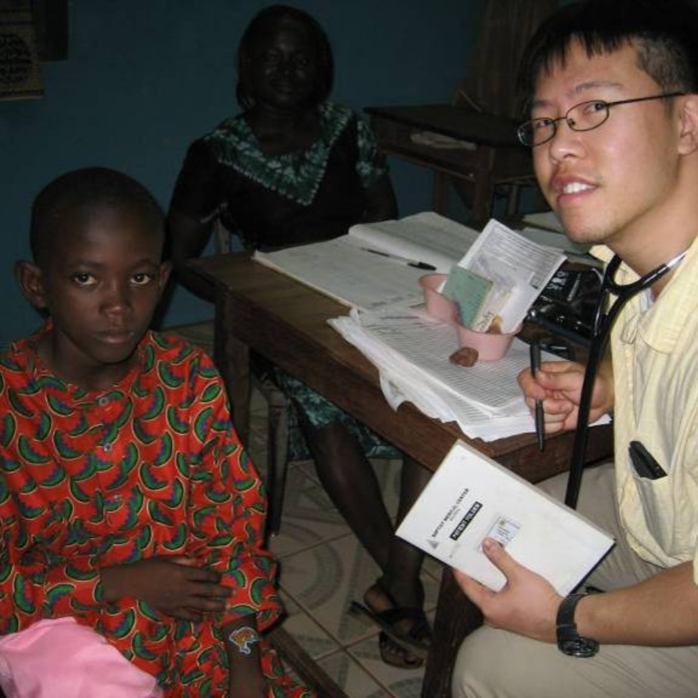 Healthcare professional seated with two patients during a consultation.