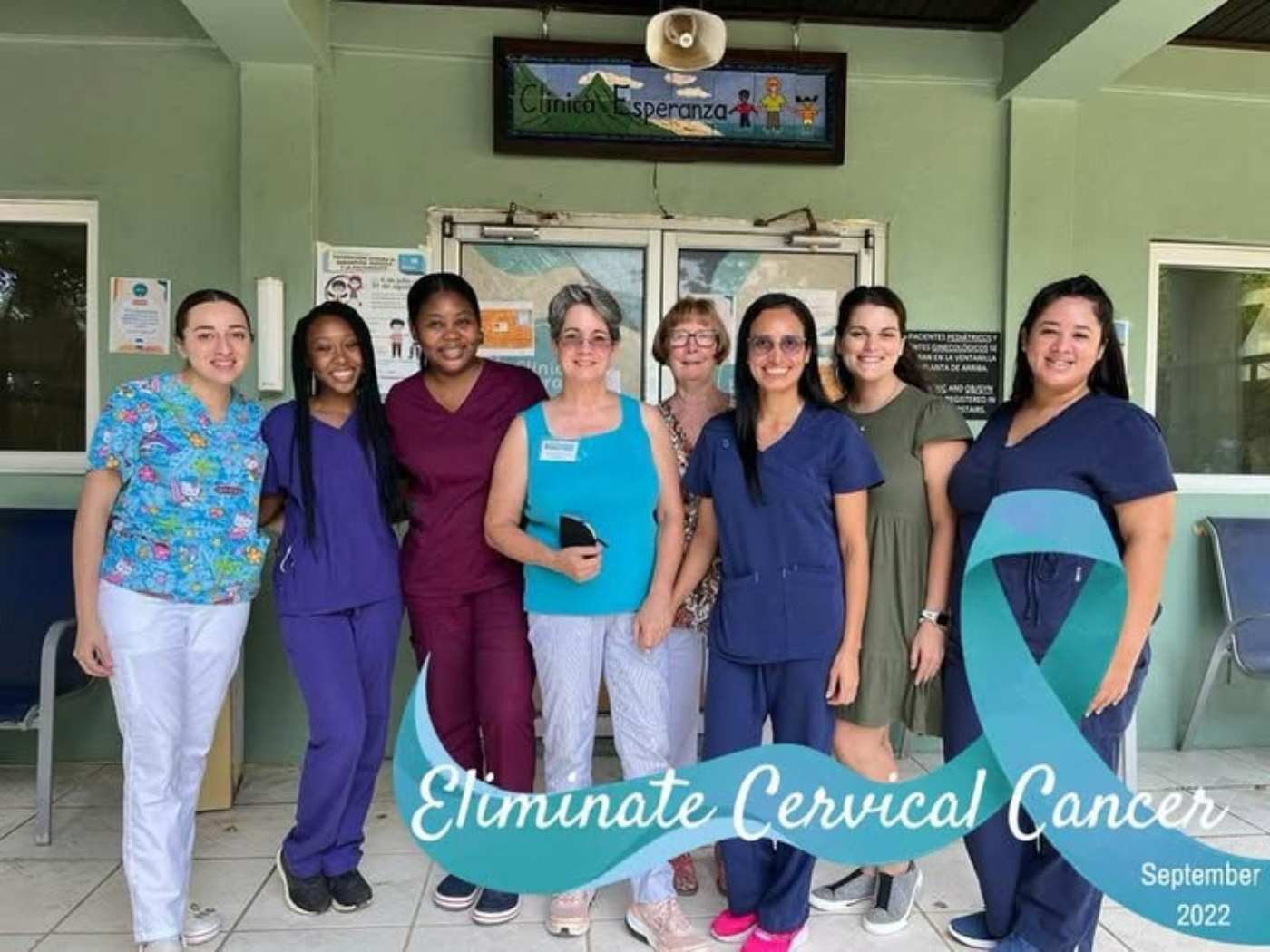 Group photo of people standing together outside a clinic entrance.