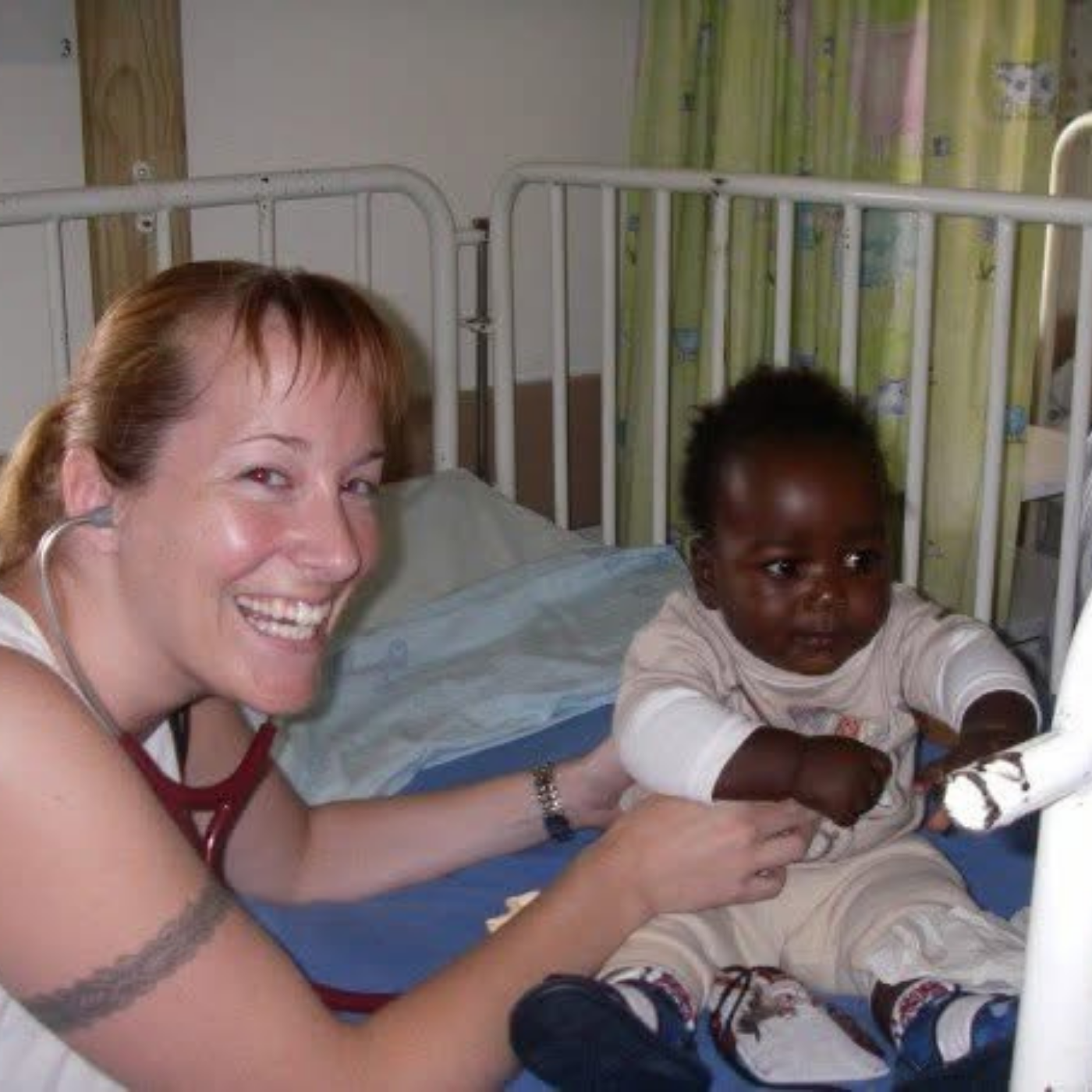 Healthcare professional using a stethoscope to examine a baby.