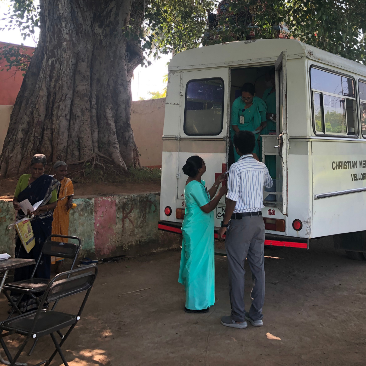 Healthcare professionals standing beside a mobile medical unit.