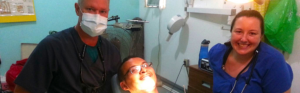 Healthcare professionals and a patient in a dental setting.