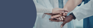 Healthcare professionals placing their hands together during a group activity.