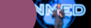 A blurred speaker in front of the INMED logo