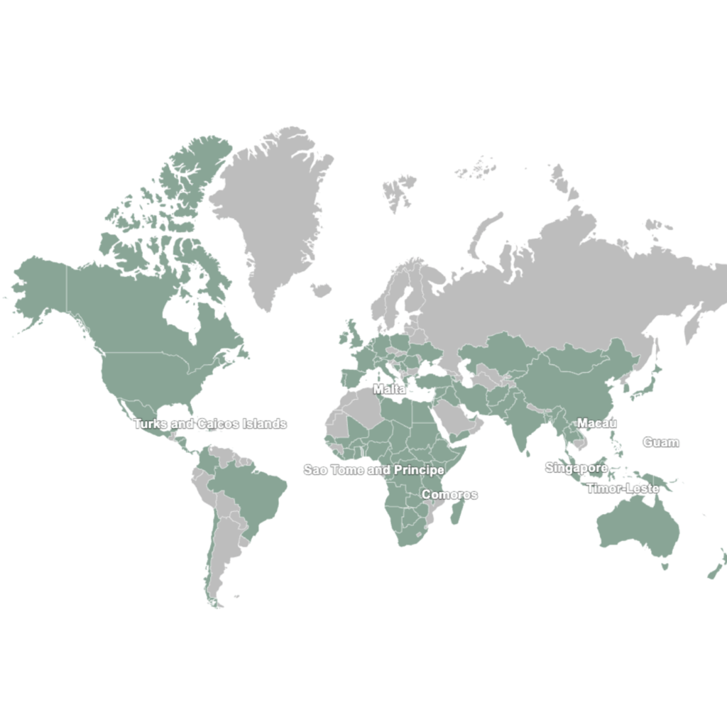 World map showing countries and territories represented by INMED learners and graduates across North America, South America, Europe, Africa, Asia, and Oceania. Small labeled countries and territories include Comoros, Guam, Macau, São Tomé and Príncipe, Singapore, Timor-Leste, Turks and Caicos Islands, and the U.S. Virgin Islands.