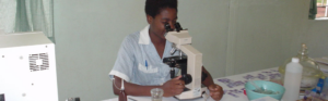 Laboratory professional using a microscope to support diagnostic services in a healthcare facility.